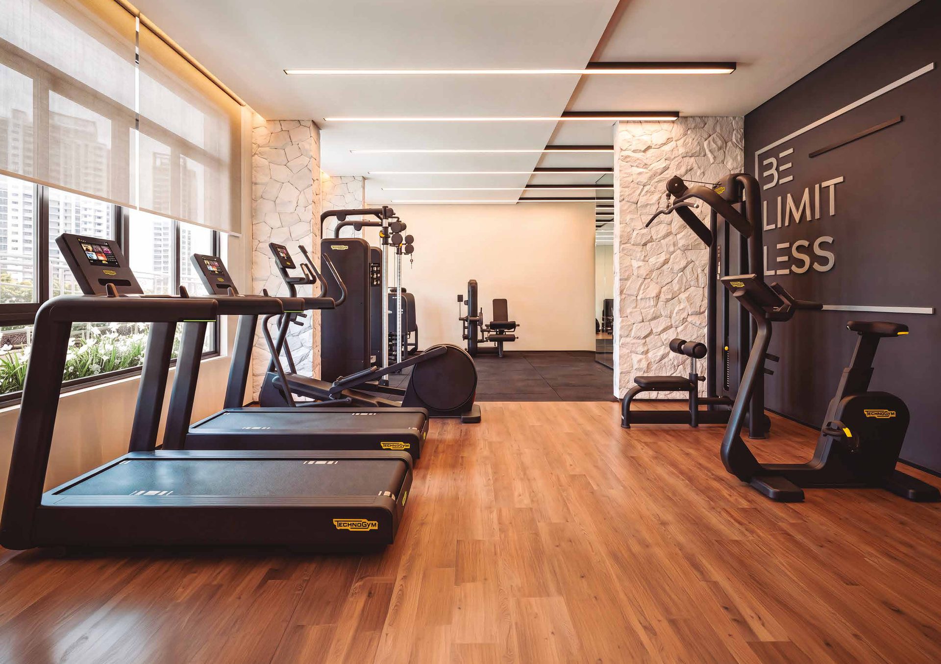Área de cardio da academia do Elysium, com esteiras e bicicletas Technogym
